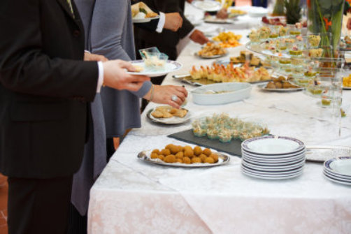 People getting food from a buffet table